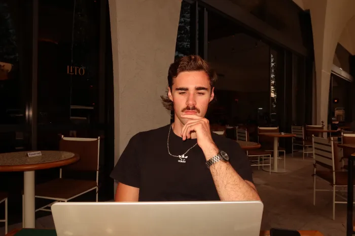 Cooper Molloy working on his laptop at a café
